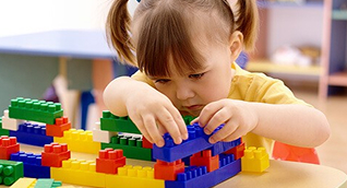 Girl putting Legos together.